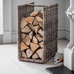 a stack of logs in a basket on the floor