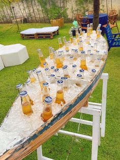 several bottles of beer are lined up on an ice - covered table in the grass