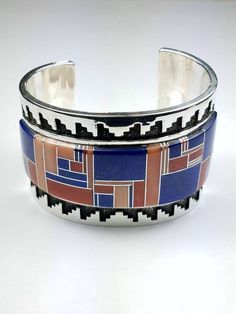 Vintage Native American Navajo handmade Sterling Silver channel inlay Coral and Lapis cuff bracelet by Tommy Jackson * Native American handmade * Navajo Tribe * Vintage * Sterling Silver * Deep stamp work * Stone: Coral and Lapis * Width: 1 3/4 inch * Length: 6 inch * Artist: Tommy Jackson For more information regarding this piece or any questions you may have please feel free to message us. Thank you! Artisan Multicolor Cuff Bracelet With Inlay, Artisan Multicolor Inlay Cuff Bracelet, Navajo Tribe, American Indian Jewelry, Native American Turquoise, Turquoise Bracelet Cuff, Sterling Necklaces, Turquoise Cuff, Bead Jewelry