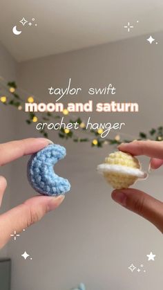 two hands holding tiny crocheted items in front of a wall with the caption taylor swift moon and saturn crochet hanger