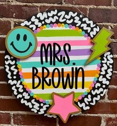 a sign that says, mrs brown on the side of a brick wall with a smiley face