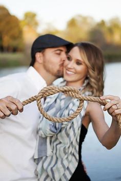 a man and woman standing next to each other with a rope in front of them