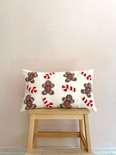 a wooden stool with a pillow on top of it and a teddy bear design on the back