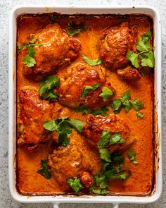 chicken curry in a white casserole dish with cilantro