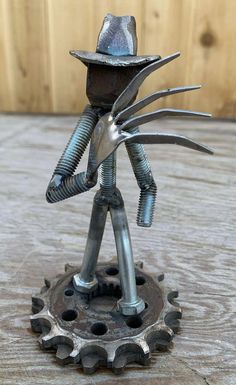 a metal figure is standing on a wooden surface