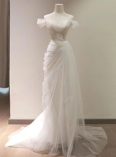 a white wedding dress on display in a room