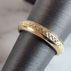 a close up of a gold ring on a black cloth