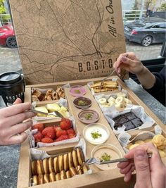 two people eating food from a box on a table with a map in the background