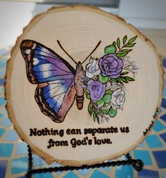 a wooden sign with a butterfly and flowers on it that says nothing can separate us from god's love