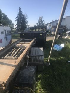 the back end of a truck with its flat bed on it's side and other trailers in the background