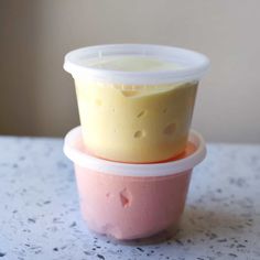 two plastic containers filled with food sitting on top of a white countertop next to each other