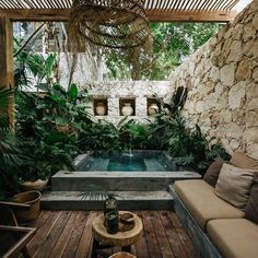 a living area with couches, tables and a small pool in the middle of it