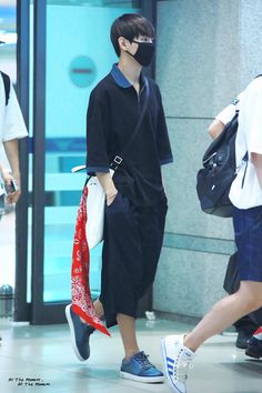 a man wearing a face mask while walking through an airport