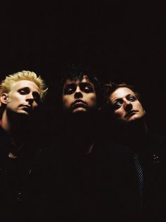 three men standing in the dark with their eyes closed