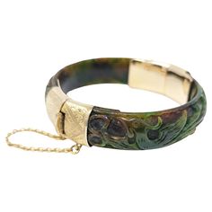 Gorgeous vintage to antique hand carved nephrite jade bracelet. Accentuated with 14k solid yellow gold, this enchanting piece features what looks to be a phoenix on one side and a dragon on the other side. Hallmarked " 585 " the European mark for 14K gold on the inside of the clasp. Safety chain is intact. Measures .6 inch in width, the interior opening is 2.25 inches in diameter (7 inches total interior length, recommended for no larger than a 6.5 to 6.75 inch wrist). Perfect for your vintage-loving sweetheart! Socially conscious women will prefer ethically sourced vintage diamonds and gems. Thrill your love with this classic piece! Luxury Vintage Carved Bracelets, Collectible Yellow Gold Jade Jewelry, Luxury Vintage Jade Bracelets, Carved Jade Bangle Bracelet, Vintage Jade Jewelry Hand-strung, Antique Bracelets, Nephrite Jade, Jade Bangle, Safety Chain