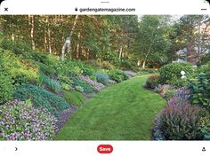 a lush green lawn surrounded by flowers and trees