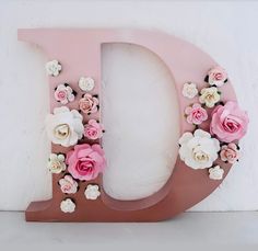 the letter d is decorated with pink and white flowers