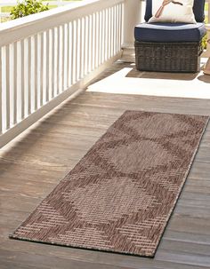 a brown area rug sitting on top of a wooden floor next to a blue chair