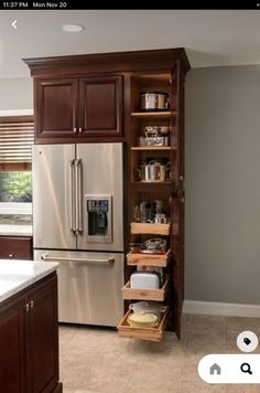 a kitchen with wooden cabinets and stainless steel refrigerator freezer next to an open drawer