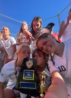 the girls soccer team is posing with their trophy