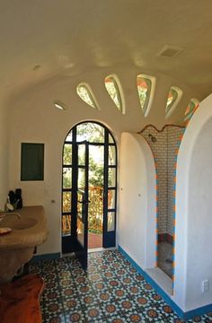 a bathroom with an arched doorway and tiled flooring, along with a large sink