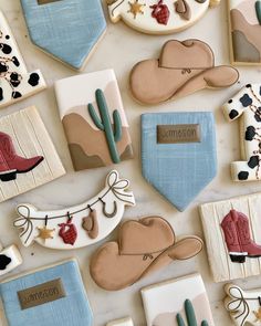 decorated cookies are arranged on a table with cowboy hats, boots and bandannas