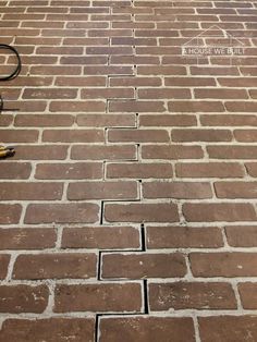 a brick wall with some tools on top of it and a building in the background