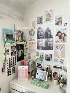 a white desk topped with a computer and lots of pictures