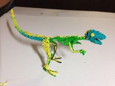 the toy lizard is made from yarn and crocheted with beads on it's tail