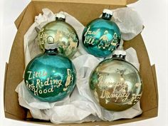 three christmas ornaments in a cardboard box