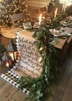 a dining room table decorated for christmas with greenery and candles