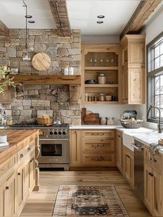 a kitchen with wooden cabinets and stone wall behind the stove top, along with an area rug on the floor