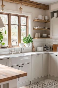 a kitchen filled with lots of white appliances and counter top space next to a window