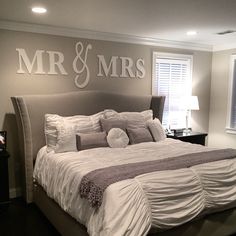 a large bed sitting in a bedroom under a mr and mrs decal on the wall