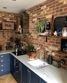 a kitchen with blue cabinets and brick walls