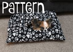 a small dog laying on top of a black and white blanket