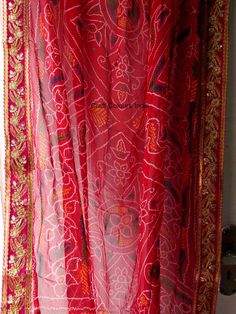 Very beautiful and gorgeous light weight red Georgette tie dye bandhej chunri with zari work. It is decorated with golden flower embroidered lace on all 4 sides. This is a ready to wear dupatta/scarf. It can be used for wedding, wedding rituals, party, bridesmaid gift, lehenga dupatta, Indian functions or events. Dimension: Length: 2 meter Width: 1.2 meter Transitional Red Dupatta With Gota Work, Red Bohemian Dupatta For Navratri, Red Zari Work Saree For Festival, Red Saree With Zari Work For Festival, Bohemian Red Traditional Wear With Bandhani Print, Red Bohemian Traditional Wear With Bandhani Print, Red Bohemian Saree For Festive Occasions, Red Bandhani Print Traditional Wear For Festival, Red Saree With Pallu For Festivals