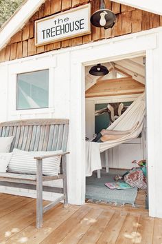 the treehouse is built into the side of a building with a hammock hanging from it's roof