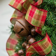 a close up of a christmas wreath with bells and ribbons on it's side