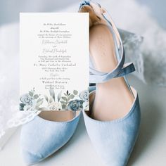 a pair of blue wedding shoes with a card in the middle