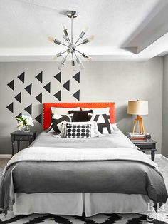 a bedroom with black and white decor on the walls, carpeted flooring and a chandelier hanging from the ceiling