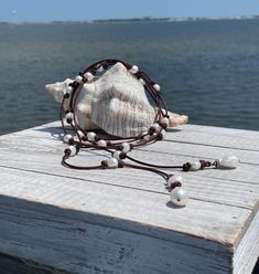 This boho style leather necklace is the perfect coastal necklace to wear dressy or casual. There are 25 freshwater baroque pearls that have been hand knotted on a beautiful rich espresso brown leather (2mm). The leather is variegated so you will see dark brown to cherry brown in the same strand.  I have barrel knotted and secured each side of the pearls all along the strand.  Each end of the necklace has a large 14-16mm baroque pearl in a creamy white. They are wire wrapped into charms. The two Bohemian Adjustable Pearl Necklace With Pearl Charm, Bohemian Adjustable Pearl Necklace With Charm, Adjustable Bohemian Pearl Necklace With Charm, Bohemian Adjustable Pearl Drop Necklace, Bohemian Single Strand Pearl Necklace For Beach, Adjustable Bohemian Pearl Drop Necklaces, Adjustable Bohemian Pearl Drop Necklace, Adjustable Pearl Drop Necklace For Beach, Elegant Adjustable Pearl Necklace For Beach