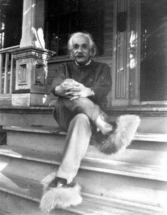 an old black and white photo of a man sitting on the steps