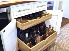 an open cabinet with bottles and glasses in it