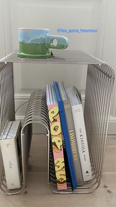 a stack of books sitting on top of a metal shelf next to a white door