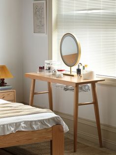 a bedroom with a bed, desk and mirror