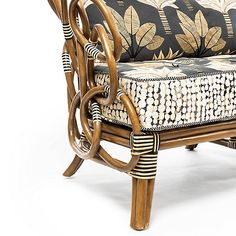 a rattan chair with black and white patterned seat cushion on it's back