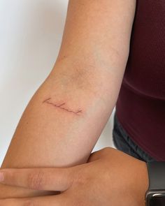 a woman's arm with the word love tattooed on her left arm, in front of a white background