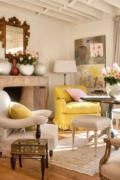 a living room filled with lots of furniture and flowers on top of a fireplace mantel