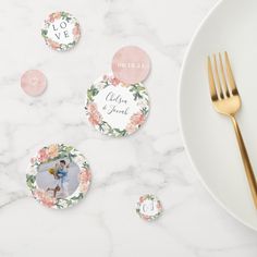 the table is set with pink and white plates, gold utensils and personalized place cards